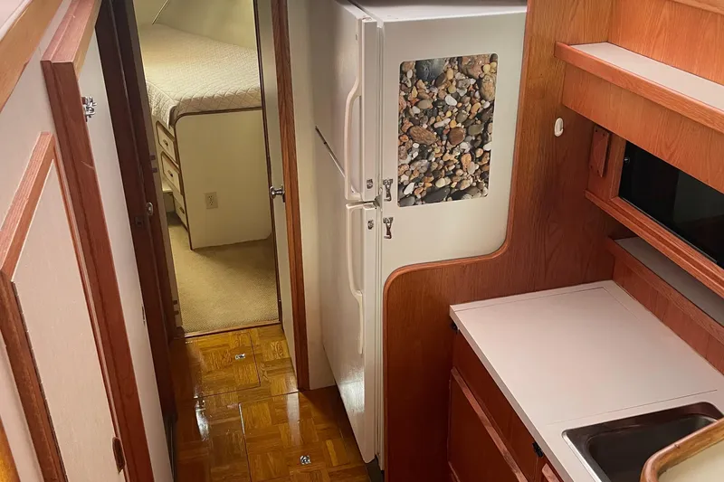 Slide: The Image of Interior of 1987 Bertram 42 Convertible yacht with kitchen and bedroom view. - 12