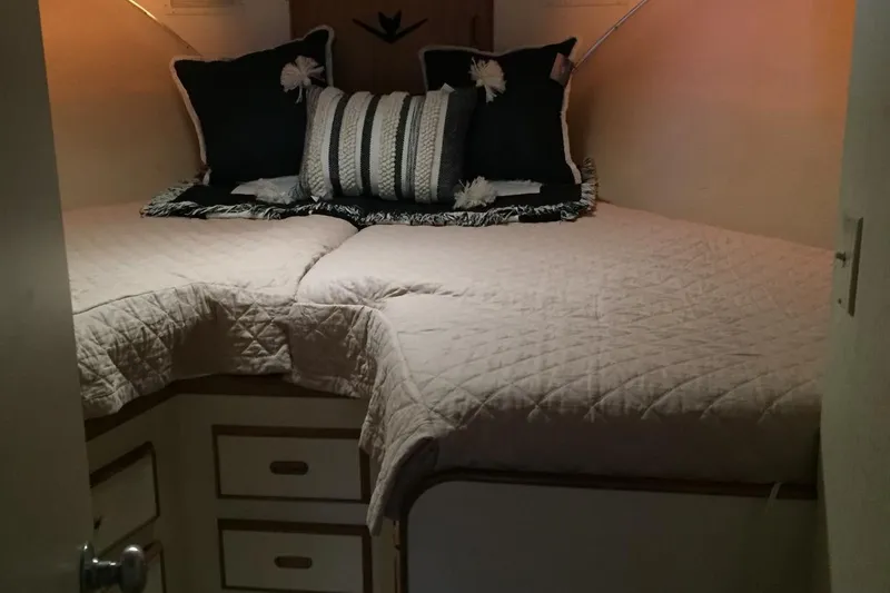 Slide: The Image of Cozy cabin interior of 1987 Bertram 42 Convertible with quilted bedding and decorative pillows. - 14