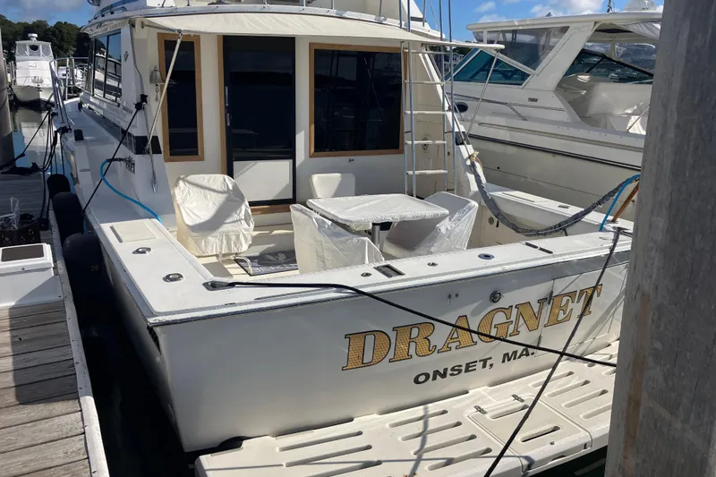 Slide: The Image of 1987 Bertram 42 Convertible boat named Dragnet docked at marina. - 2