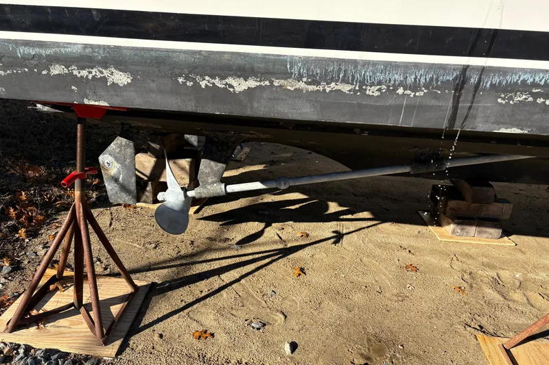 Slide: The Image of 1987 Bertram 42 Convertible boat hull with propeller and support stands. - 23