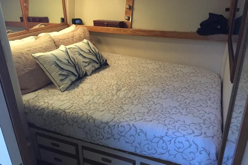 Slide: The Image of Cozy bedroom in 1987 Bertram 42 Convertible yacht with elegant bedding and pillows. - 8
