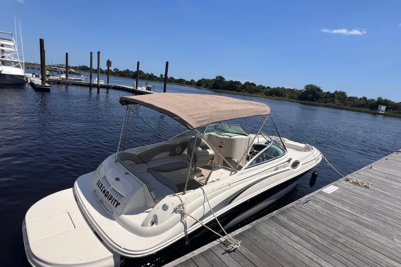 Slide: The Image of 2003 Sea Ray 240 Sundeck boat docked on a sunny day with a canopy. - 3