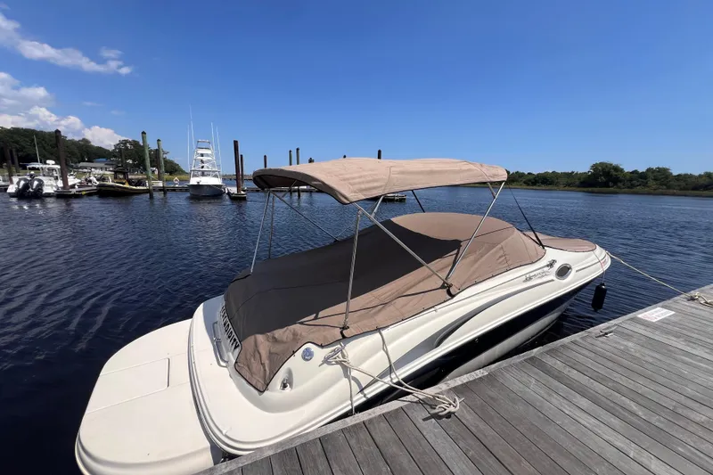Slide: The Image of 2003 Sea Ray 240 Sundeck boat docked, featuring spacious seating and sleek design. - 5