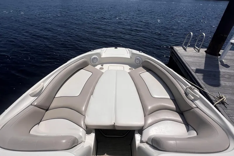 Slide: The Image of 2003 Sea Ray 240 Sundeck interior with seating, docked by the water. - 7
