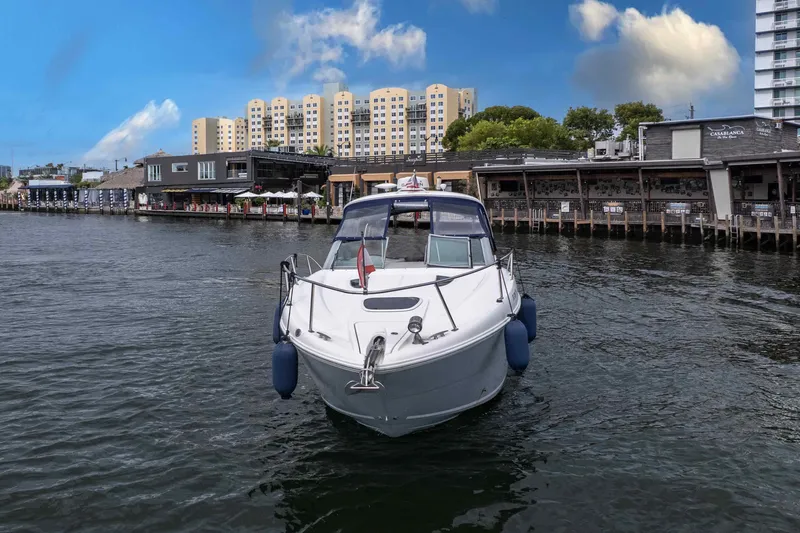 Slide: The Image of 2007 Sea Ray 290 Sundancer boat on water near waterfront buildings. - 10