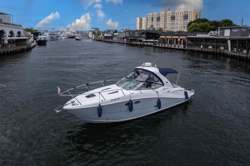 Slide: The Image of 2007 Sea Ray 290 Sundancer yacht cruising in a scenic urban waterway. - 2