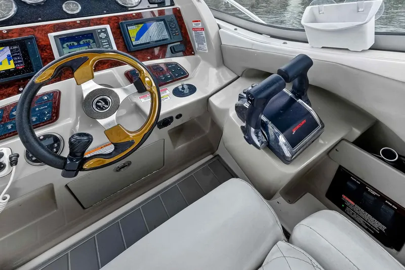 Slide: The Image of 2007 Sea Ray 290 Sundancer helm with steering wheel, controls, and navigation displays. - 23