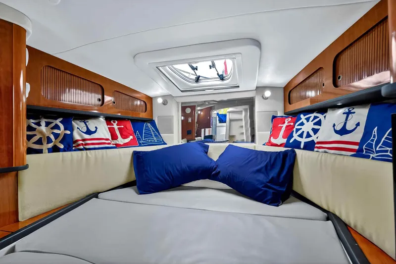 Slide: The Image of Interior cabin of 2007 Sea Ray 290 Sundancer with nautical-themed pillows and wood accents. - 26