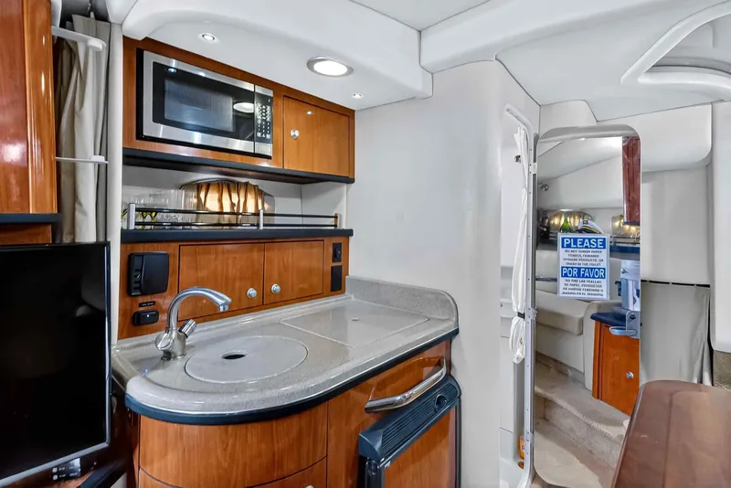 Slide: The Image of 2007 Sea Ray 290 Sundancer interior with kitchenette, microwave, and modern amenities. - 33
