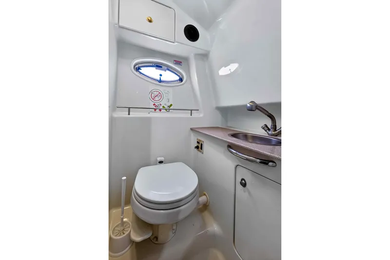 Slide: The Image of 2007 Sea Ray 290 Sundancer boat bathroom with toilet, sink, and storage cabinet. - 36