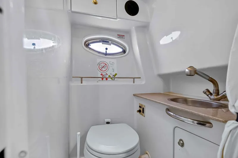 Slide: The Image of 2007 Sea Ray 290 Sundancer bathroom with sink, toilet, and porthole window. - 37