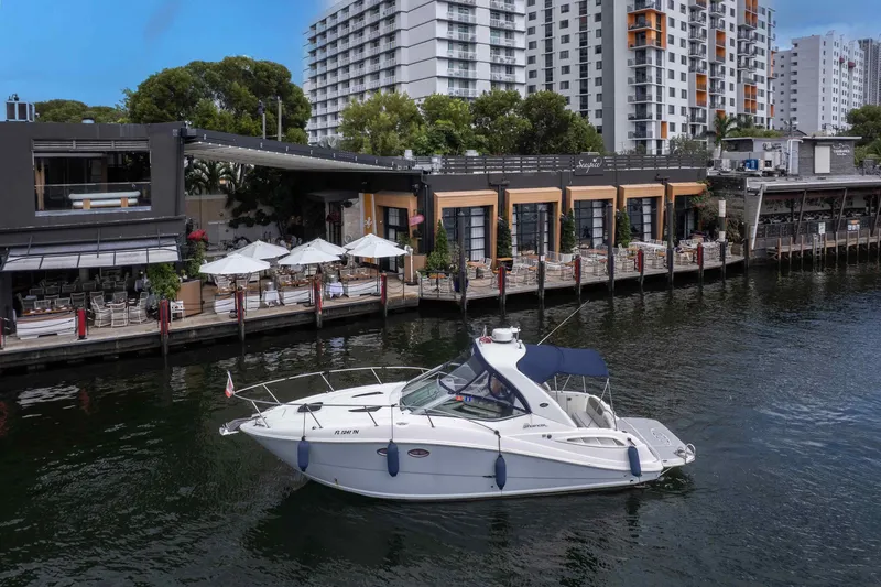 Slide: The Image of 2007 Sea Ray 290 Sundancer yacht docked near waterfront restaurant and modern buildings. - 7