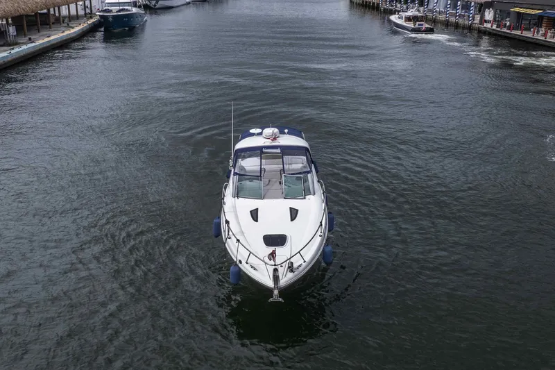 Slide: The Image of 2007 Sea Ray 290 Sundancer cruising in a calm marina channel. - 9