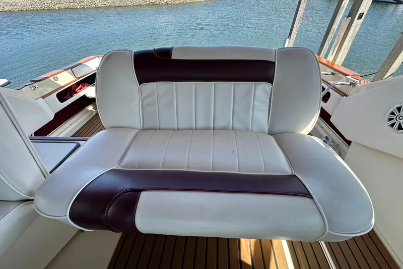 Slide: The Image of White and maroon seat on 1987 Sea Ray 340 Sundancer boat, overlooking water. - 18