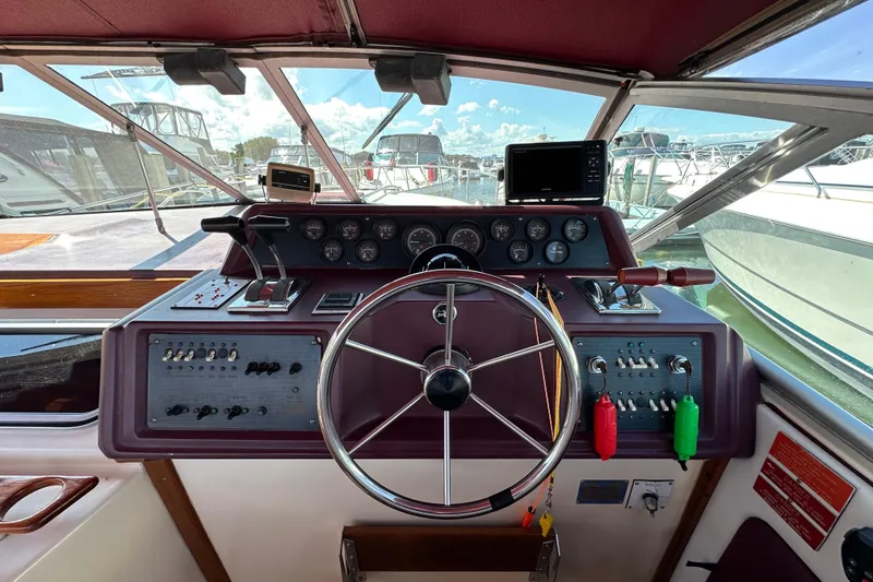 Slide: The Image of 1987 Sea Ray 340 Sundancer helm with steering wheel, gauges, and controls. - 20