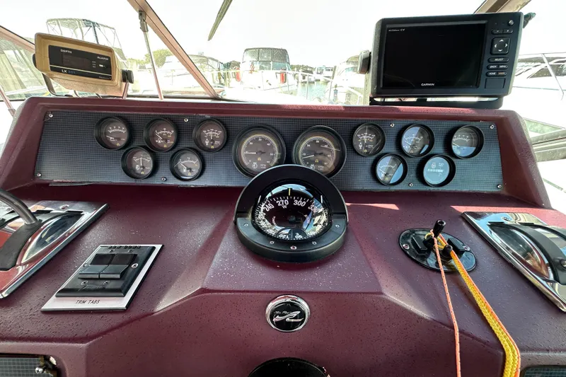 Slide: The Image of 1987 Sea Ray 340 Sundancer dashboard with gauges, compass, and navigation equipment. - 21