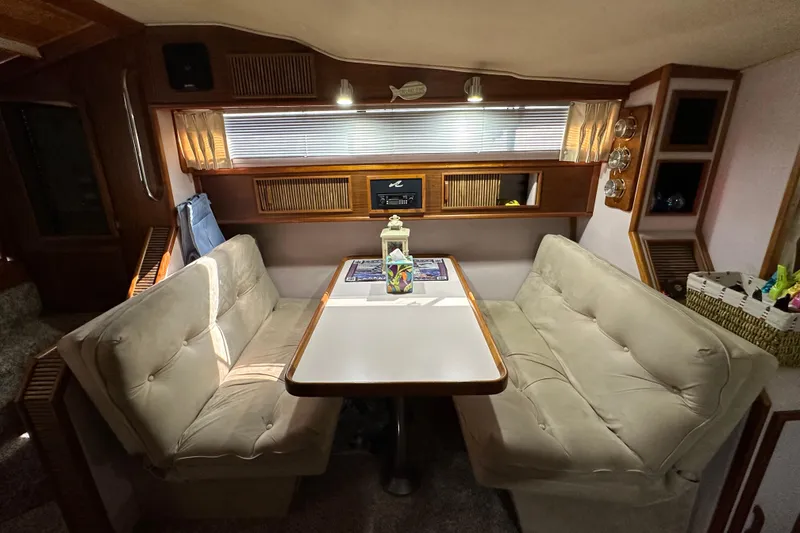 Slide: The Image of 1987 Sea Ray 340 Sundancer interior with cozy dining area and plush seating. - 26