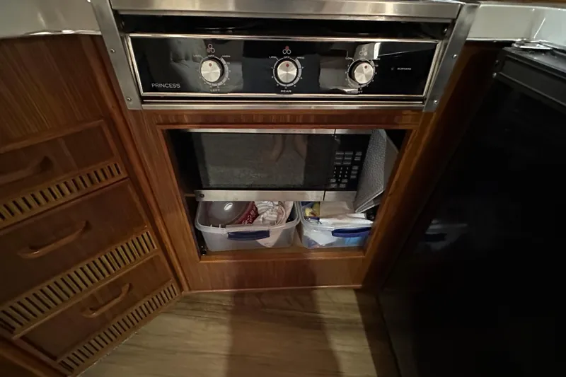 Slide: The Image of 1987 Sea Ray 340 Sundancer kitchen with stove, storage drawers, and microwave. - 28