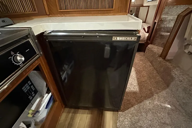 Slide: The Image of 1987 Sea Ray 340 Sundancer interior with fridge and kitchen area. - 33