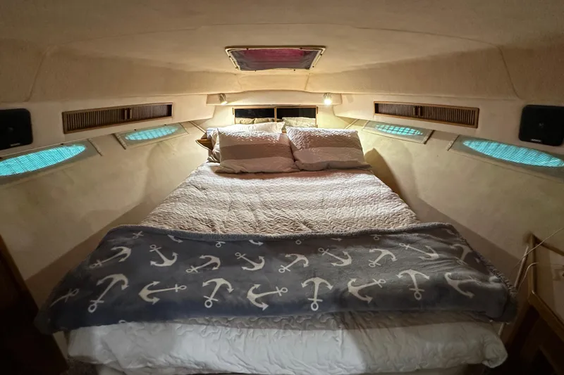 Slide: The Image of Cozy cabin interior of 1987 Sea Ray 340 Sundancer with nautical-themed bedding. - 37