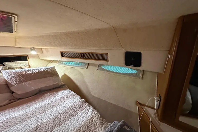 Slide: The Image of Interior cabin of 1987 Sea Ray 340 Sundancer with cozy bedding and ambient lighting. - 38
