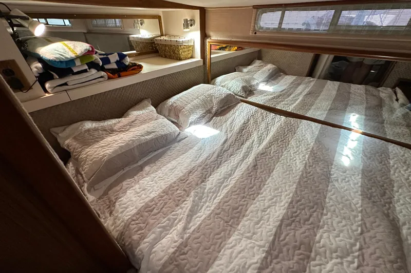 Slide: The Image of Cozy cabin interior of 1987 Sea Ray 340 Sundancer with neatly arranged bedding. - 42