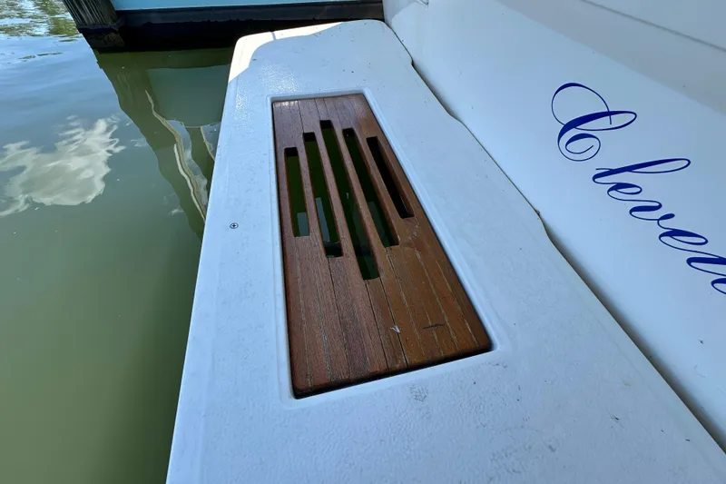 Slide: The Image of 1987 Sea Ray 340 Sundancer swim platform with wooden insert, docked by calm water. - 8