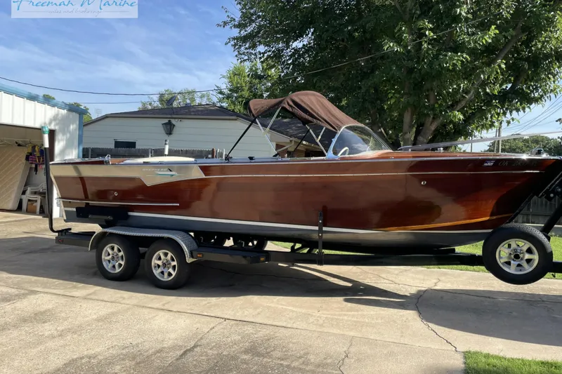 Slide: The Image of 1964 Shepherd 22 boat on trailer, polished wood finish, parked outdoors. - 11