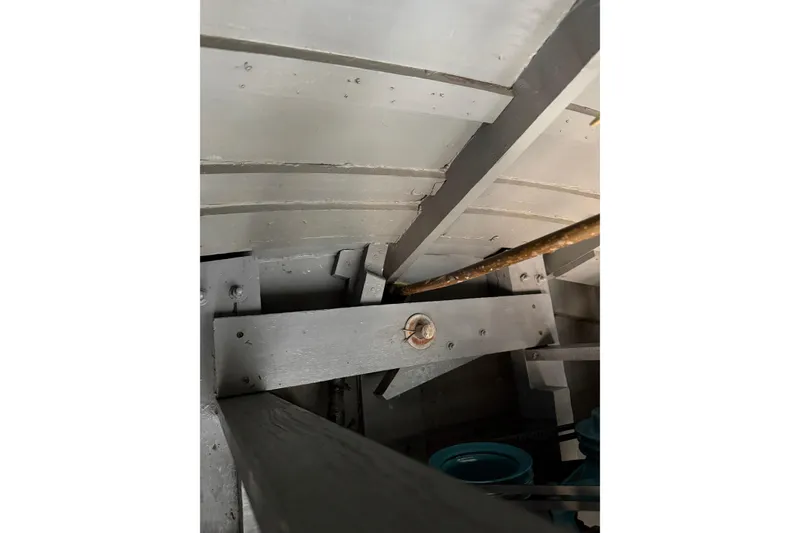 Slide: The Image of Interior view of a 1964 Shepherd 22 boat, showcasing wooden beams and structural details. - 13