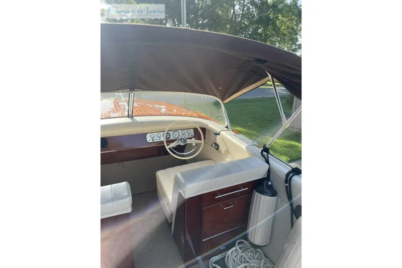 Slide: The Image of 1964 Shepherd 22 boat interior with vintage steering wheel and dashboard, under canopy. - 3