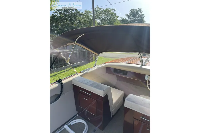 Slide: The Image of 1964 Shepherd 22 boat interior with canopy, featuring cushioned seating and wooden accents. - 4