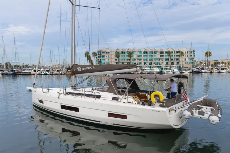 Slide: The Image of 2024 Dufour 470 yacht docked in marina, featuring sleek design and modern amenities. - 14