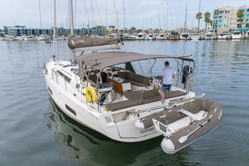 Slide: The Image of 2024 Dufour 470 yacht docked in marina, featuring spacious deck and modern design. - 15