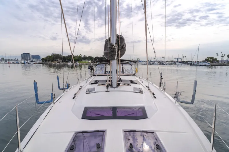 Slide: The Image of 2024 Dufour 470 sailboat docked in a calm marina, showcasing sleek deck design. - 19