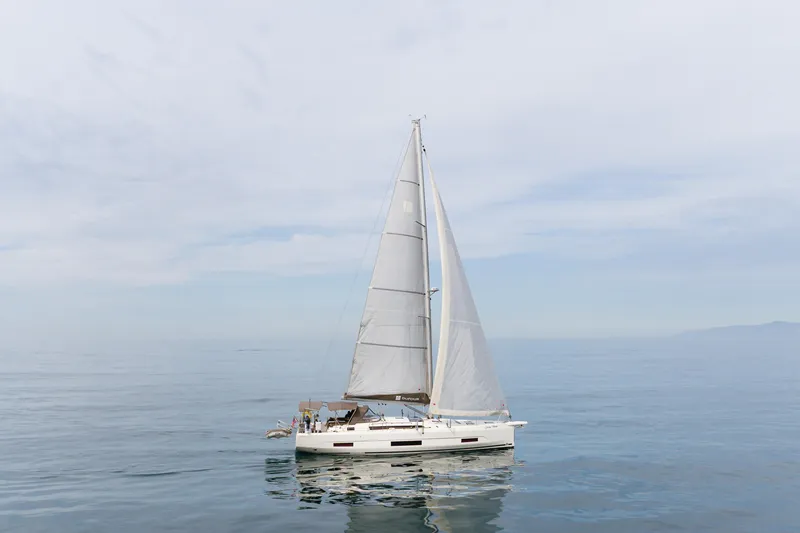 Slide: The Image of 2024 Dufour 470 sailboat on calm sea under clear sky. - 2