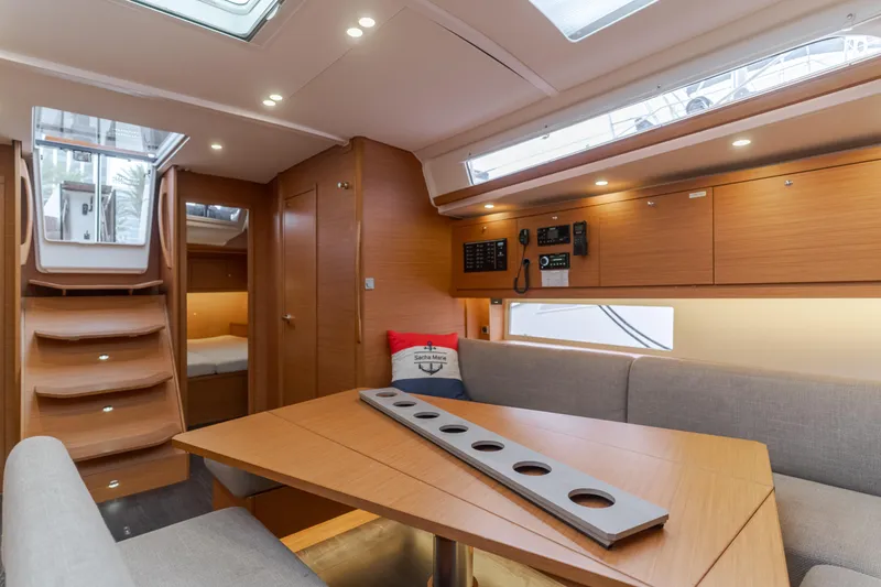 Slide: The Image of 2024 Dufour 470 yacht interior with modern wood finish and cozy seating area. - 30