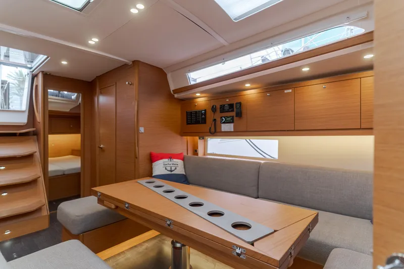 Slide: The Image of 2024 Dufour 470 yacht interior with modern wood finish and cozy seating area. - 31