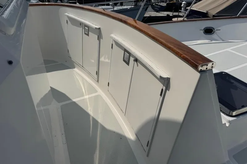 Slide: The Image of 2006 DeFever 52 Euro yacht deck with storage compartments and wooden railing. - 11