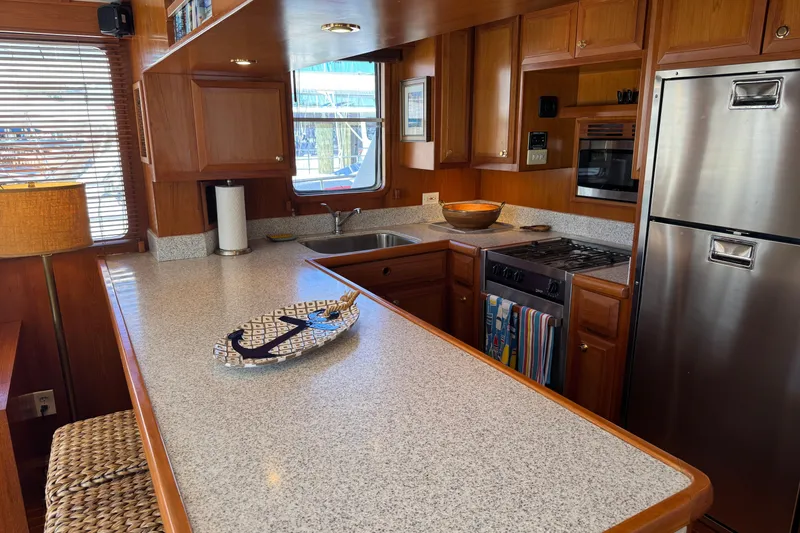 Slide: The Image of Luxurious 2006 DeFever 52 Euro yacht kitchen with wood cabinetry and modern appliances. - 24