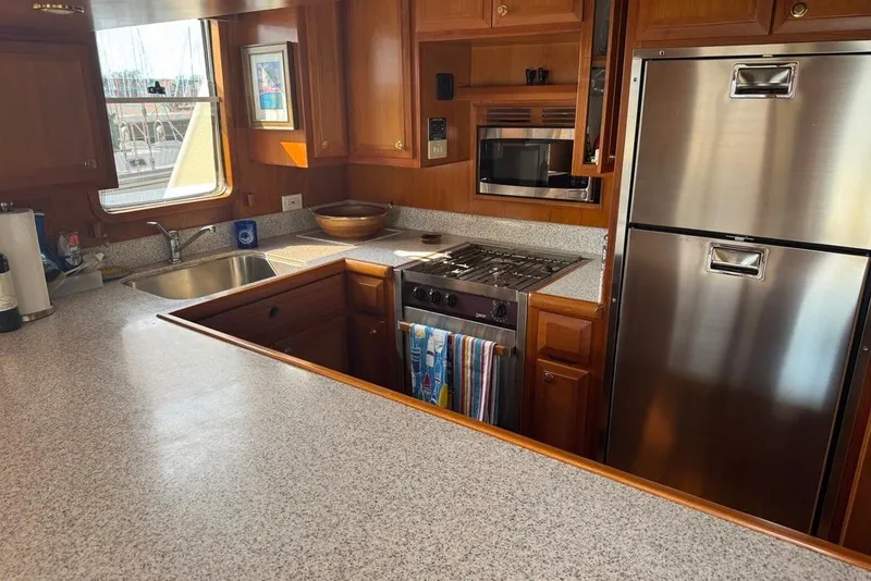Slide: The Image of Kitchen interior of 2006 DeFever 52 Euro yacht with modern appliances and wood cabinetry. - 25