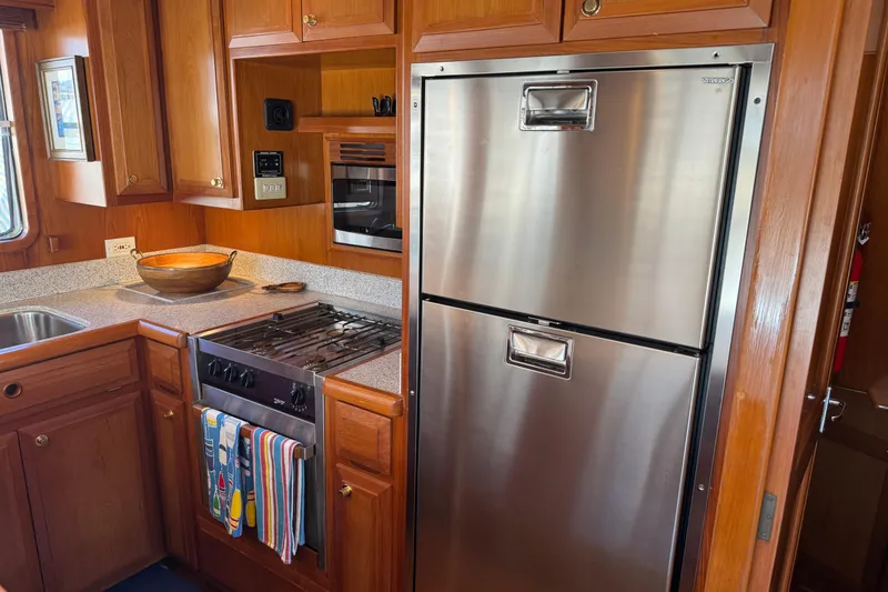 Slide: The Image of 2006 DeFever 52 Euro yacht kitchen with stainless steel appliances and wooden cabinetry. - 27