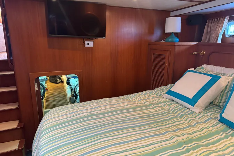 Slide: The Image of Cozy bedroom in 2006 DeFever 52 Euro yacht with striped bedding and wall-mounted TV. - 44
