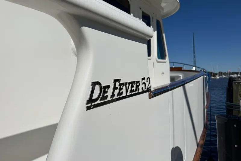 Slide: The Image of 2006 DeFever 52 Euro yacht docked, showcasing sleek design and branding. - 50