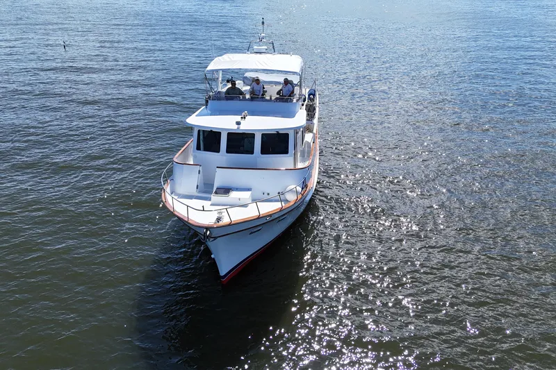 Slide: The Image of 2006 DeFever 52 Euro yacht cruising on open water, viewed from the front. - 58