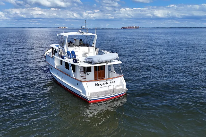 Slide: The Image of 2006 DeFever 52 Euro yacht cruising on open water under a partly cloudy sky. - 59