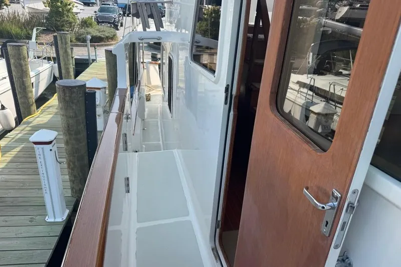 Slide: The Image of 2006 DeFever 52 Euro yacht docked, showcasing side deck and wooden door. - 8