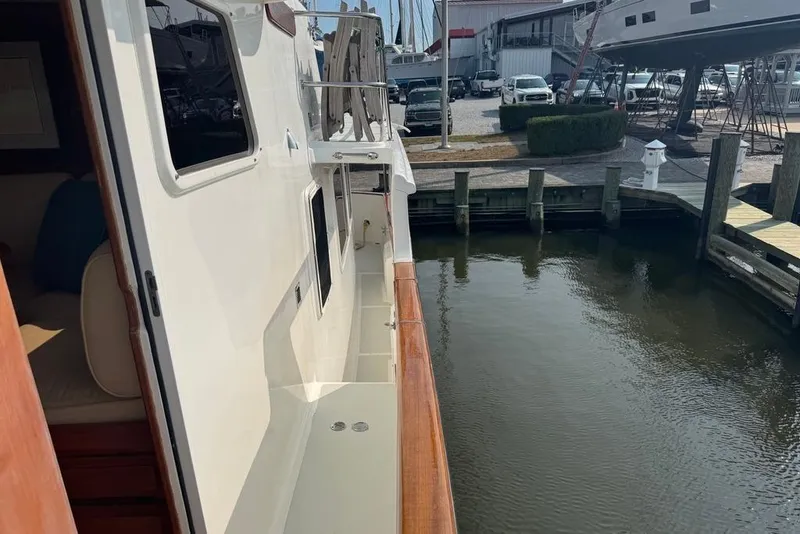 Slide: The Image of 2006 DeFever 52 Euro yacht docked at marina, side view with water reflection. - 9