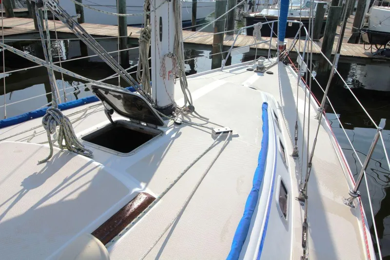 Slide: The Image of 1987 Catalina 34 sailboat deck with open hatch, docked at marina. - 10