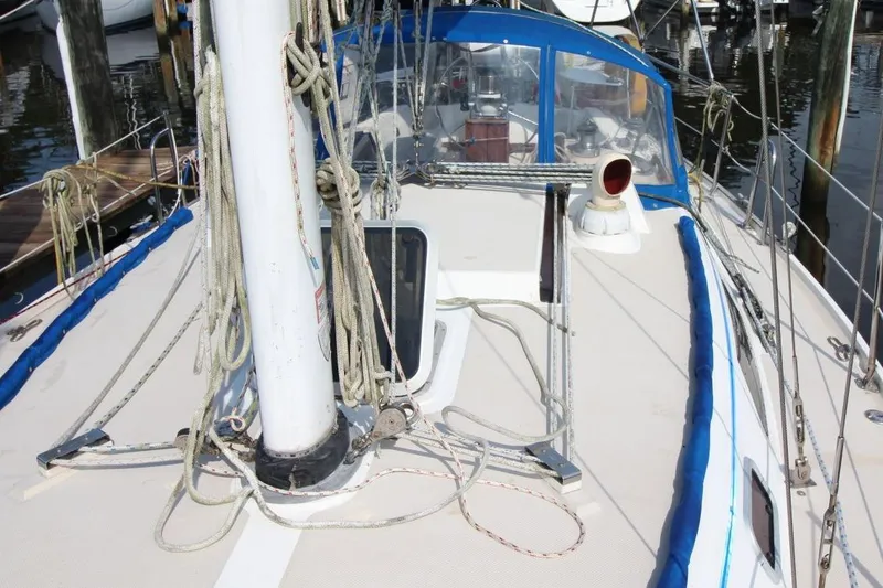 Slide: The Image of 1987 Catalina 34 sailboat deck with rigging and blue trim in marina. - 11