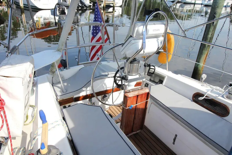 Slide: The Image of Cockpit of a 1987 Catalina 34 sailboat with steering wheel and American flag. - 12